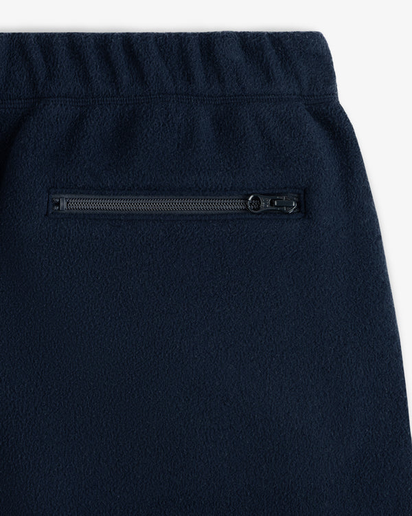 Close-up of Crest Fleece Sweatpant in navy with elastic waistband and a horizontal zippered pocket.
