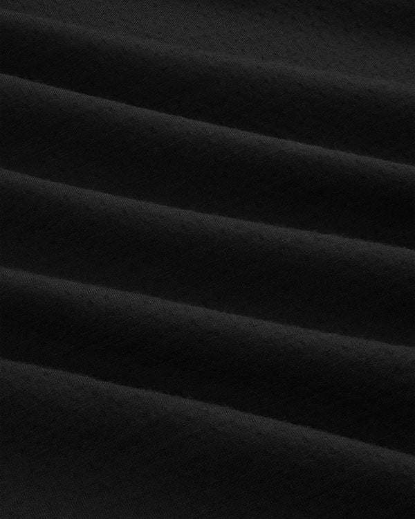 Close-up of ALD / The North Face DOTKNIT™ Wool Quarter Zip’s soft black fabric with gentle, rippled folds.
