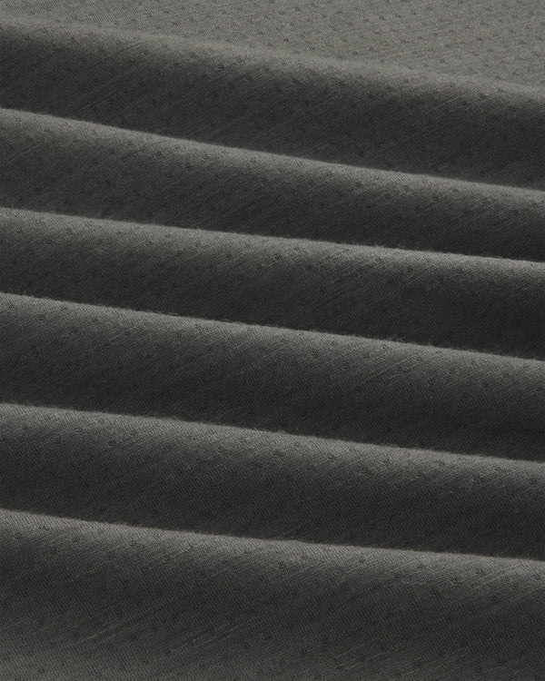 Close-up of ALD/The North Face DOTKNIT™ Wool Quarter Zip in dark grey with ribbed, diagonally folded textured fabric.