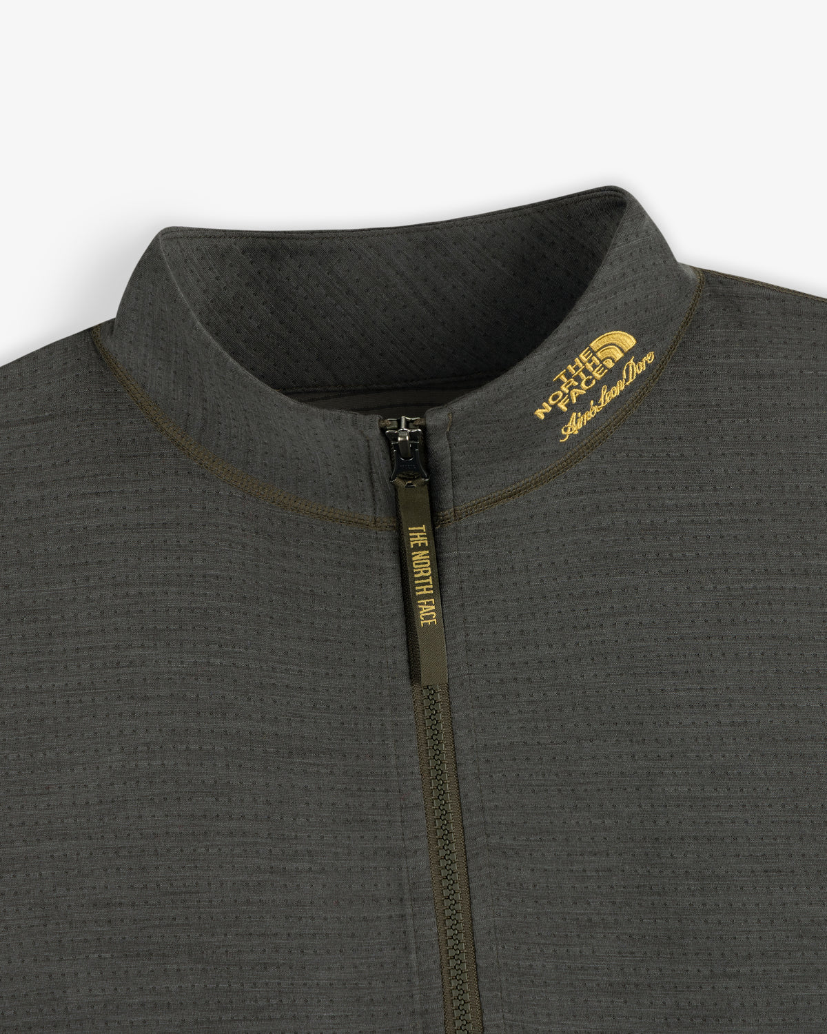 Close-up of a gray ALD / The North Face DOTKNIT™ Wool Quarter Zip with zipper and yellow logo on the collar.