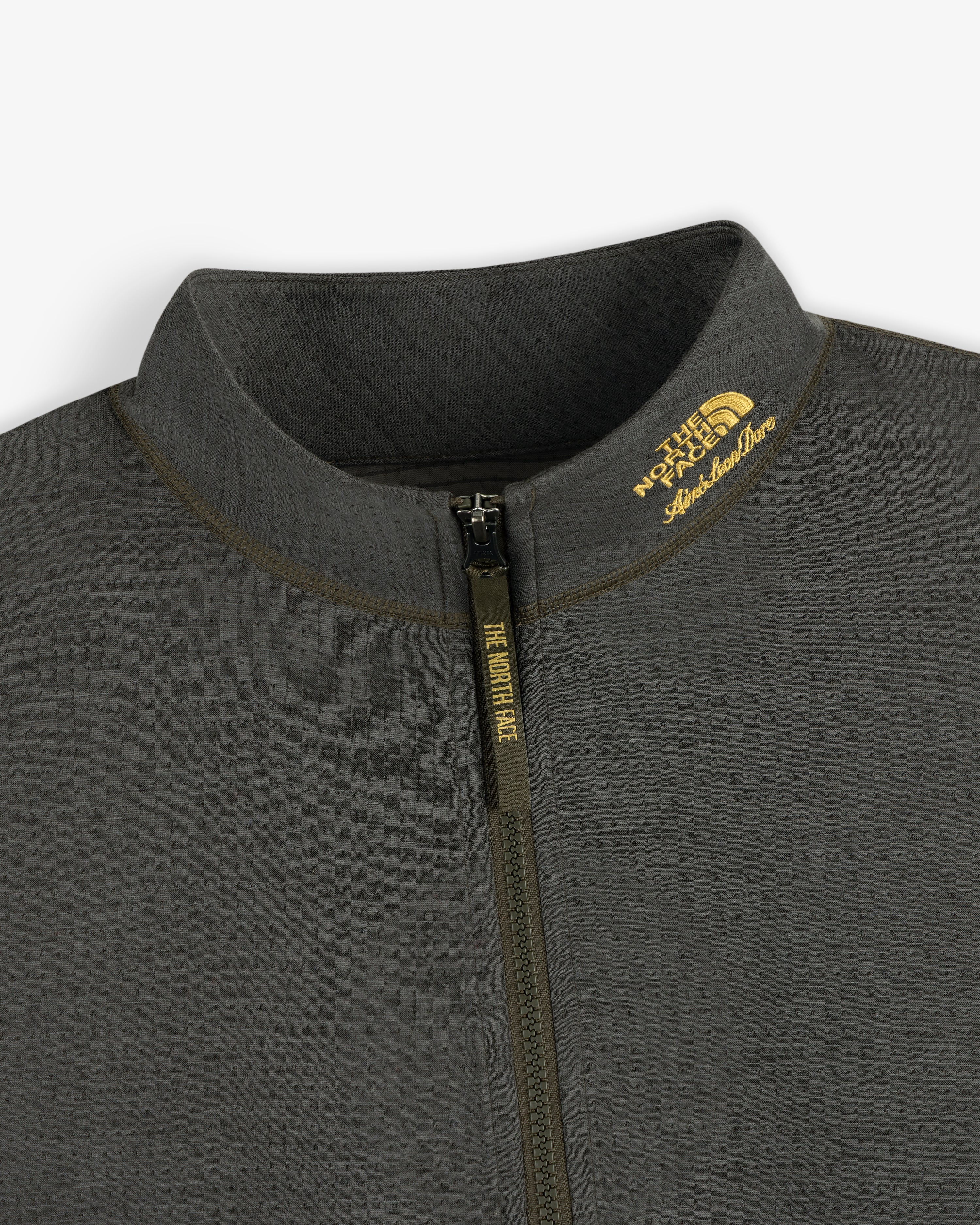 Close-up of a gray ALD / The North Face DOTKNIT™ Wool Quarter Zip with zipper and yellow logo on the collar.