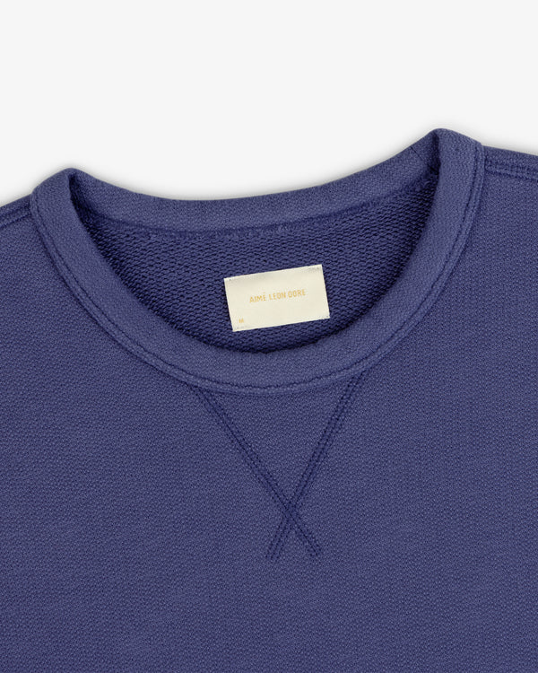 Close-up of a Stone Washed Marina Crewneck Sweatshirt with a visible collar label reading Aime Leon Dore.
