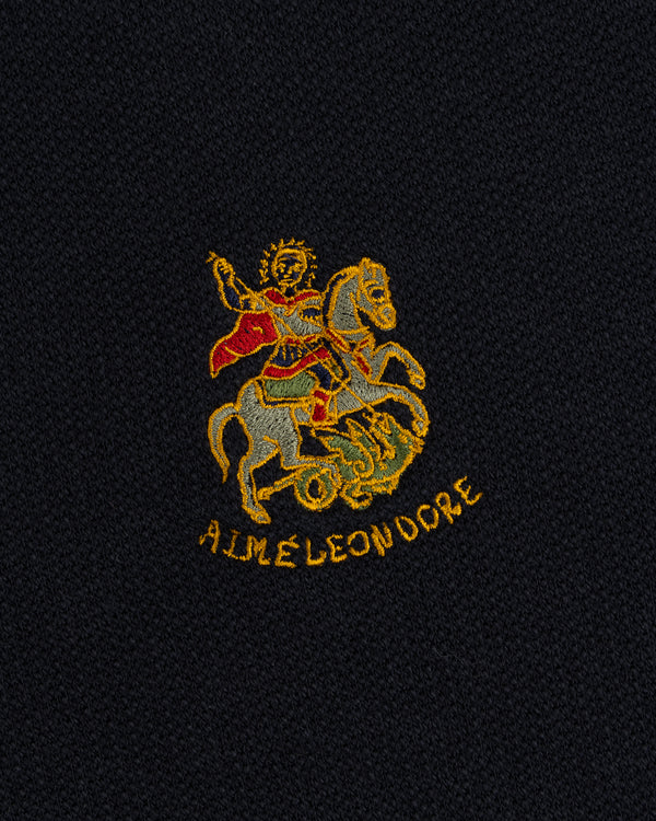 Saint George slays a dragon, AIME LEON DORE text below, on the Saint George Track Jacket’s dark fabric.