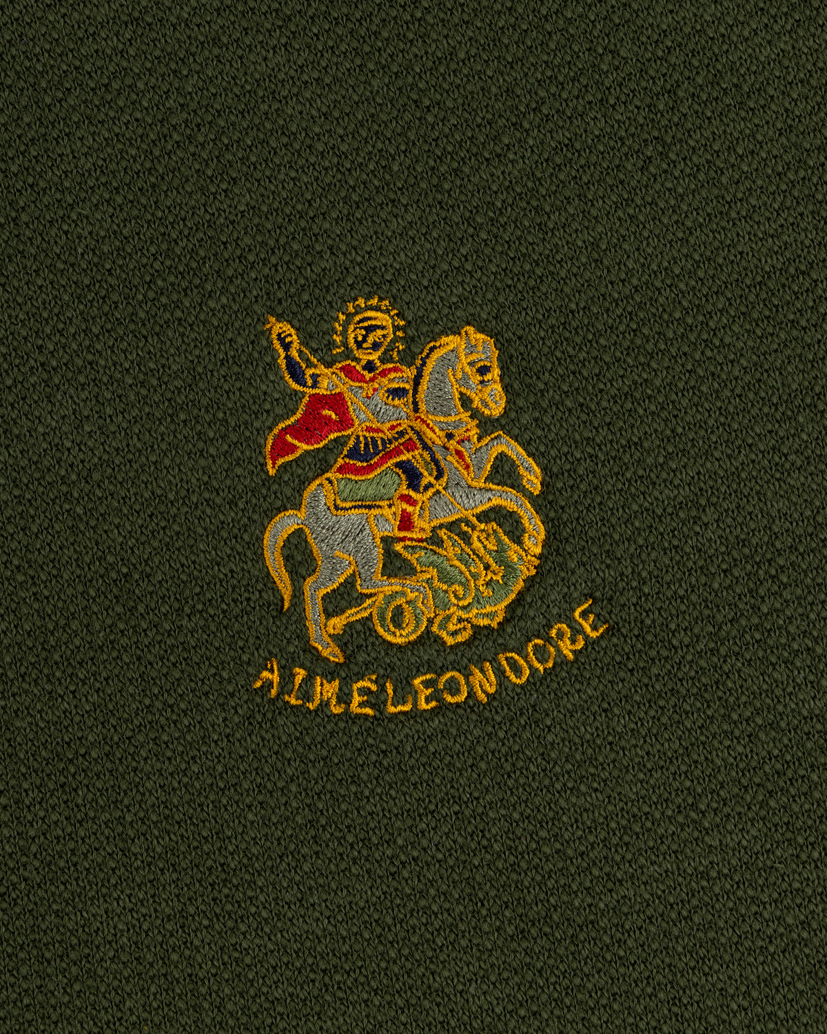 Saint George Track Jacket with embroidered knight and AIME LEON DORE text on dark green fabric.