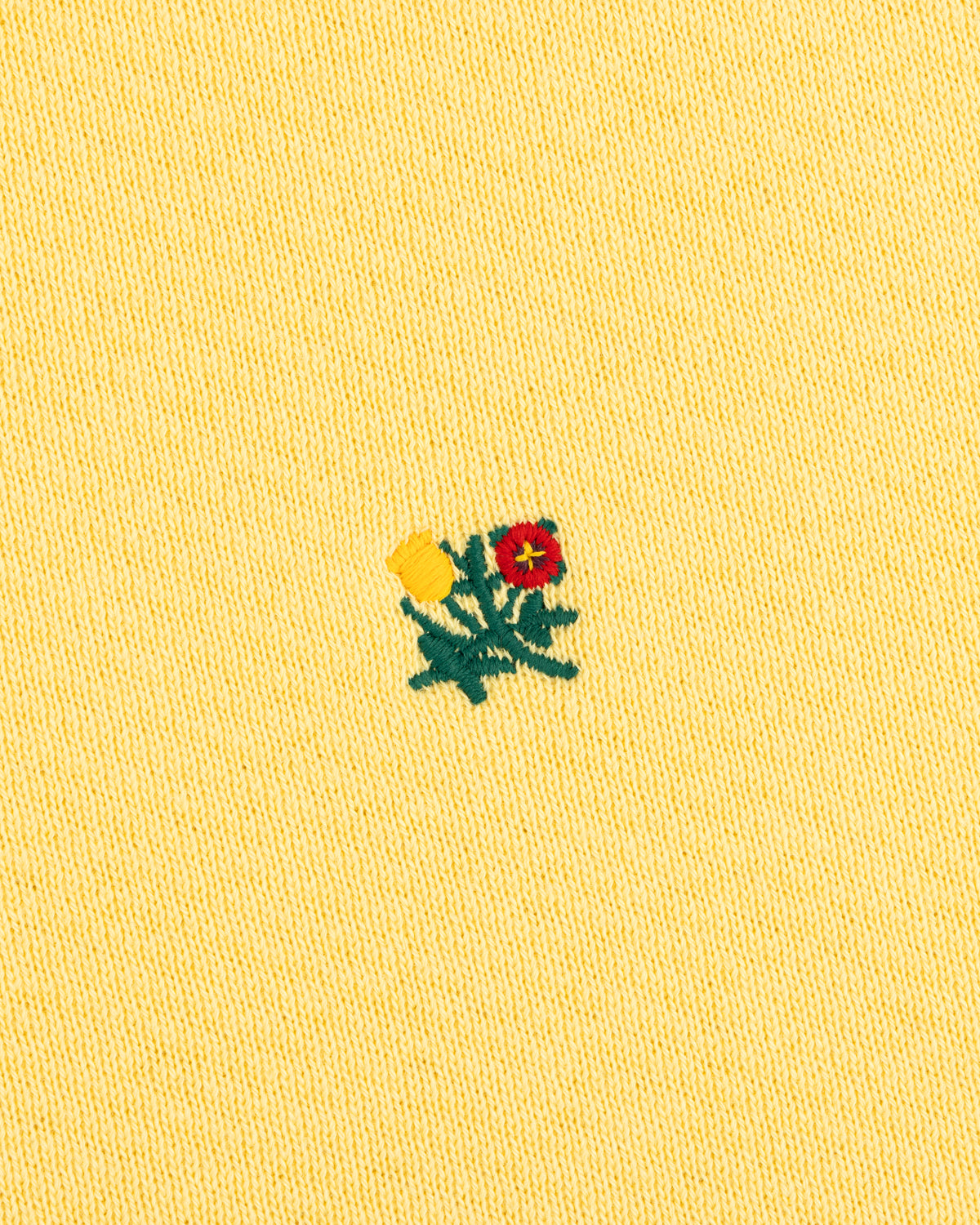 Crest Crewneck Sweatshirt in pale yellow with an embroidered design of two flowers and green leaves.