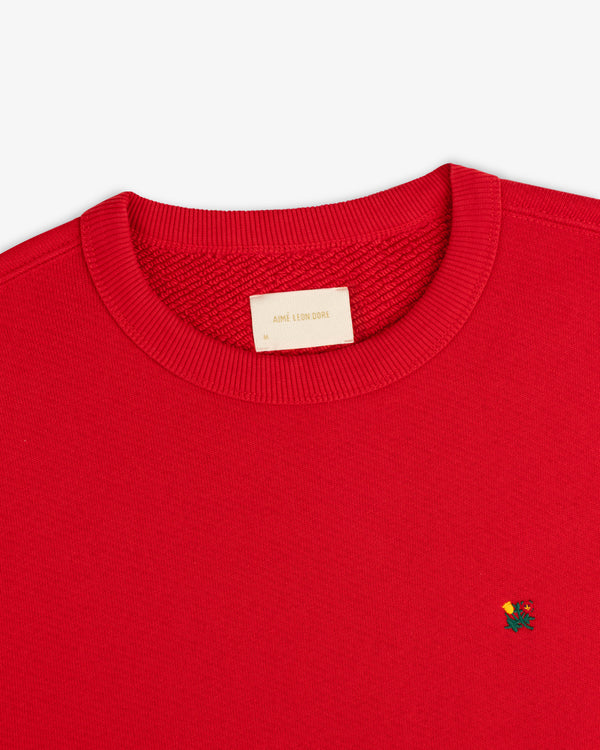 Red Crest Crewneck Sweatshirt with small floral embroidery on the chest and a brand label at the inner neckline.