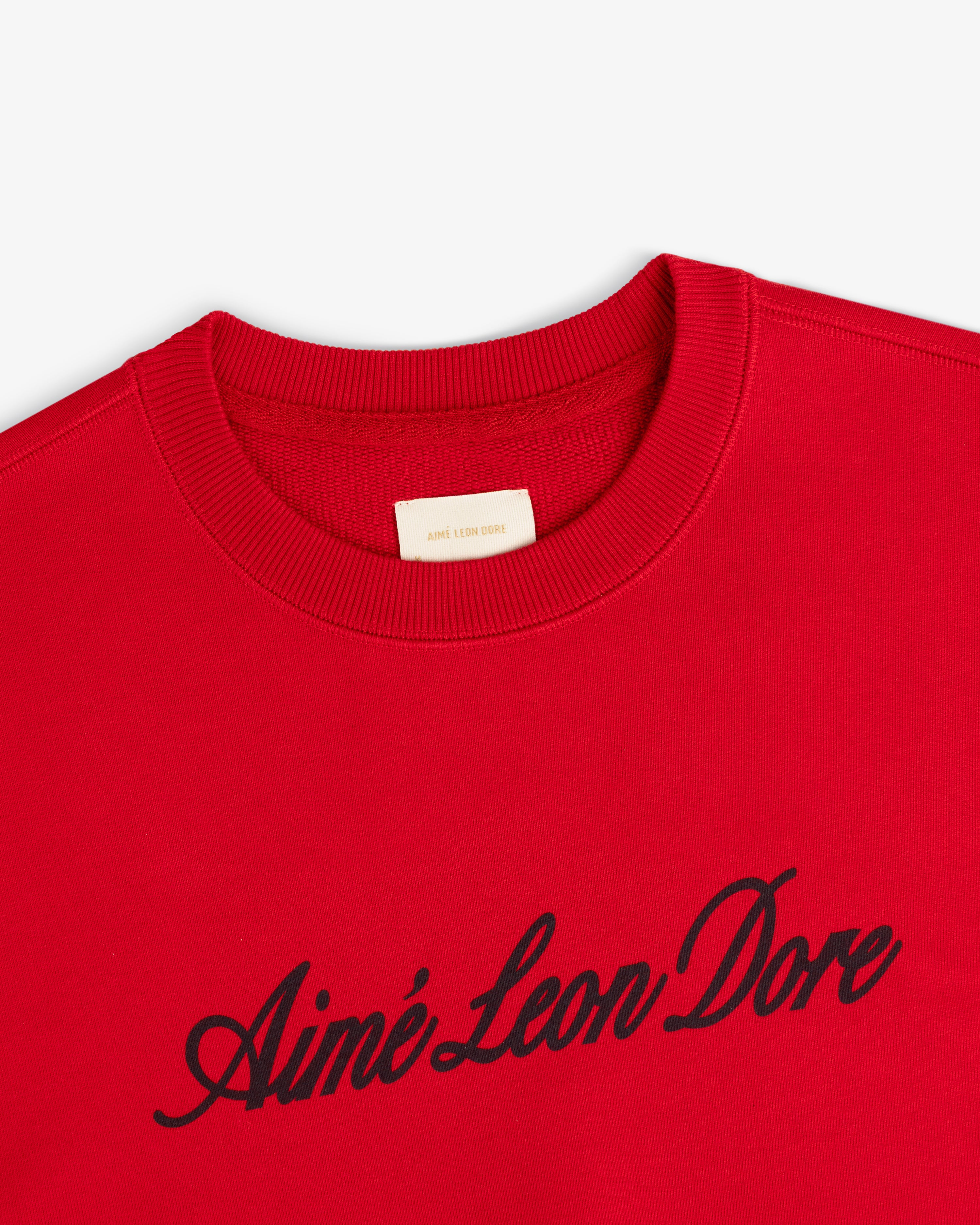 Vintage Script Crewneck Sweatshirt in red with black Aimé Leon Dore script across the chest.