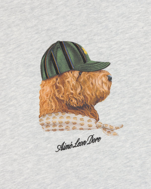 Buddy Crewneck Sweatshirt featuring an embroidered dog in a green cap and scarf on a light background with logo below.