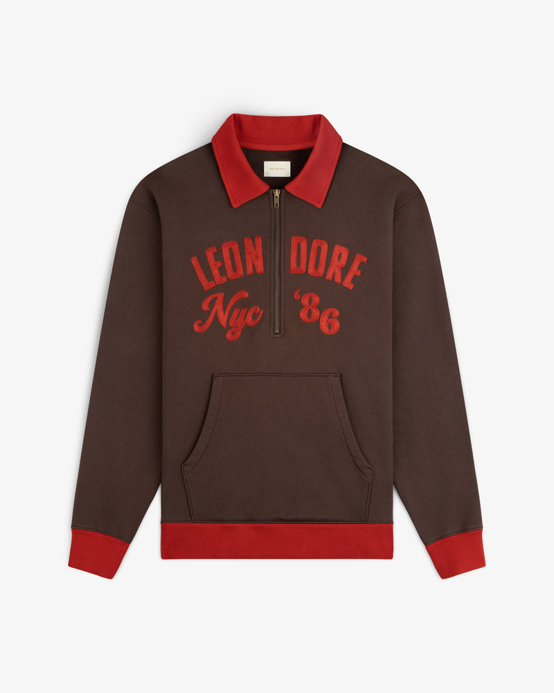 Brown Chainstitch ’86 Half Zip Pullover with a red collar, cuffs, and hem, featuring Leon Dore Nyc 86 on the chest.