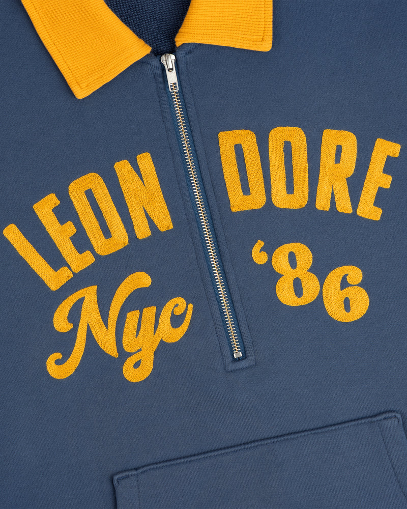 Chainstitch ’86 Half Zip Pullover in blue with a yellow collar and yellow Leon Dore Nyc 86 embroidery.