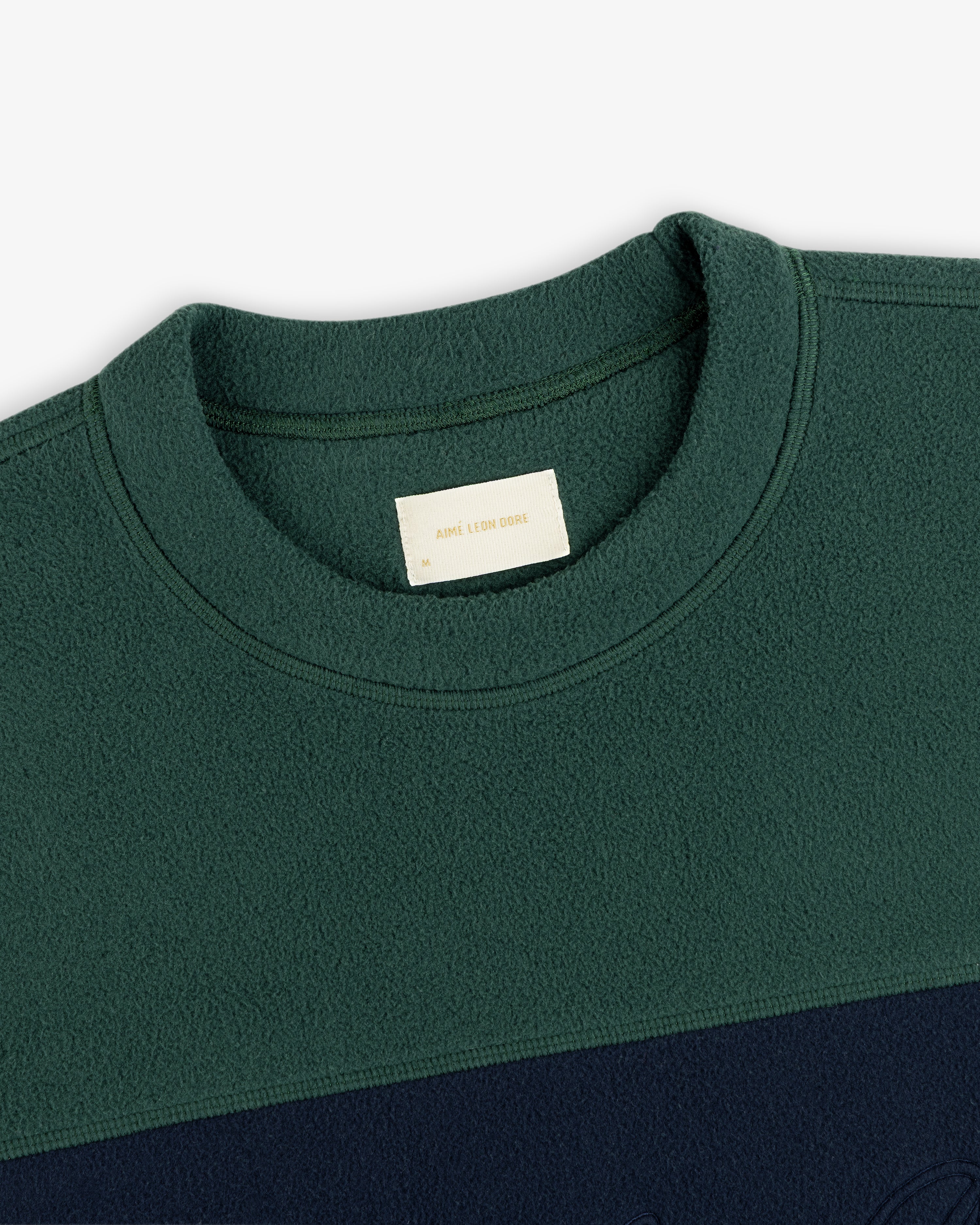 Fleece Script Paneled Crewneck Sweatshirt in forest green and navy blue color-blocked fleece with an interior brand label.