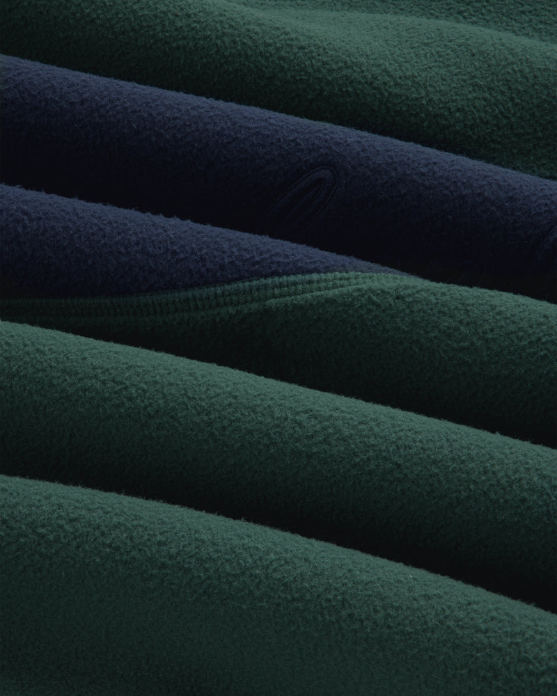 Close-up of a dark green and navy blue Fleece Script Paneled Crewneck Sweatshirt with visible seams.