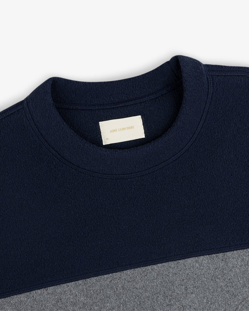 Fleece Script Paneled Crewneck Sweatshirt in navy and grey color-blocked with a brand label at the inner neckline.