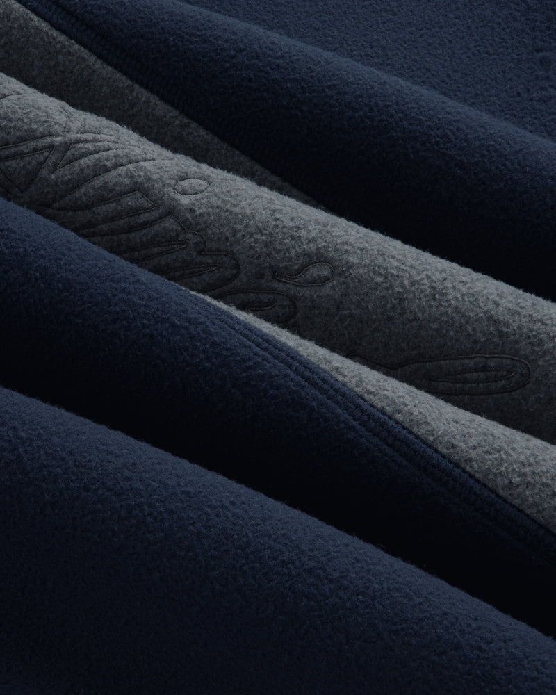 Close-up of a navy and grey Fleece Script Paneled Crewneck Sweatshirt with embroidered script detailing.