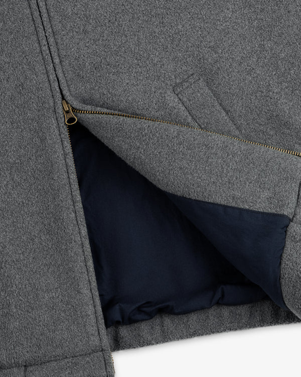 Close-up of Crest Fleece Casual Jacket: gray with a gold zipper, dark blue lining, and visible interior pocket.