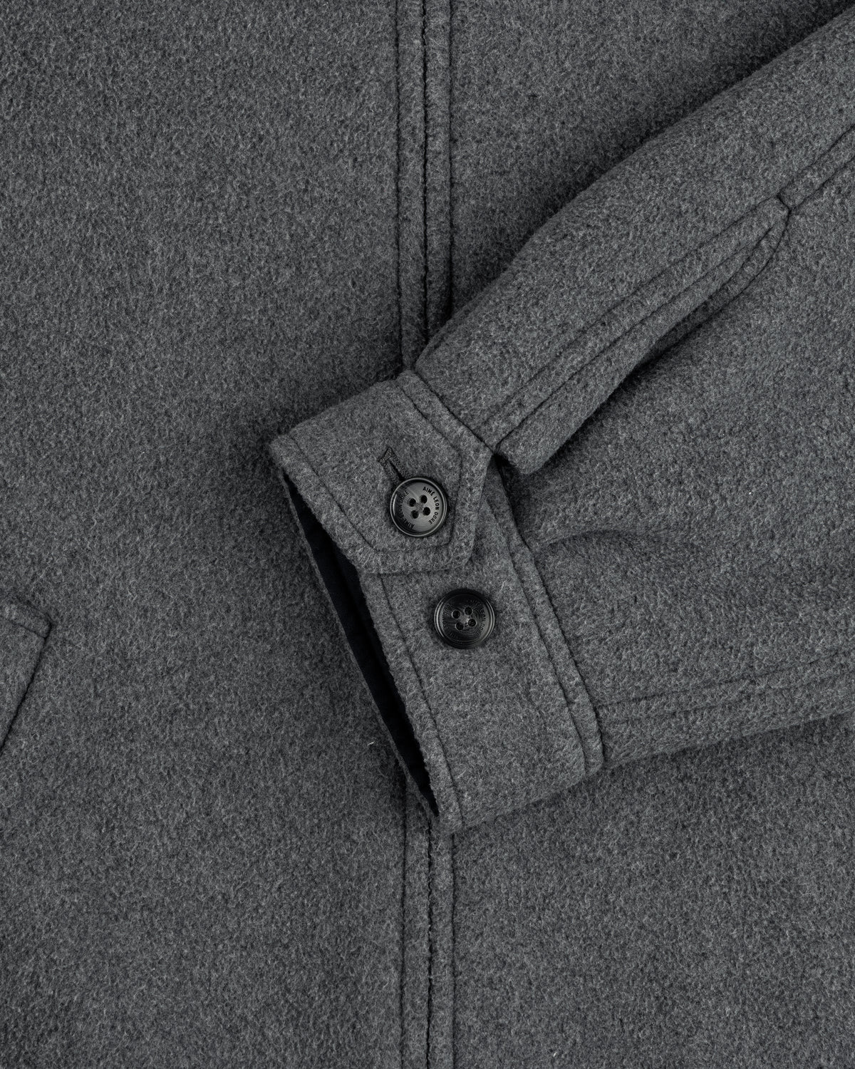 Close-up of Crest Fleece Casual Jacket sleeve in gray, showing two black buttons and a partially visible pocket.