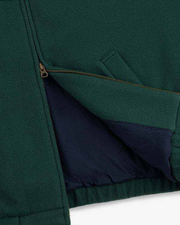 Close-up of the Crest Fleece Casual Jacket in green, featuring a gold zipper and navy blue inner lining.