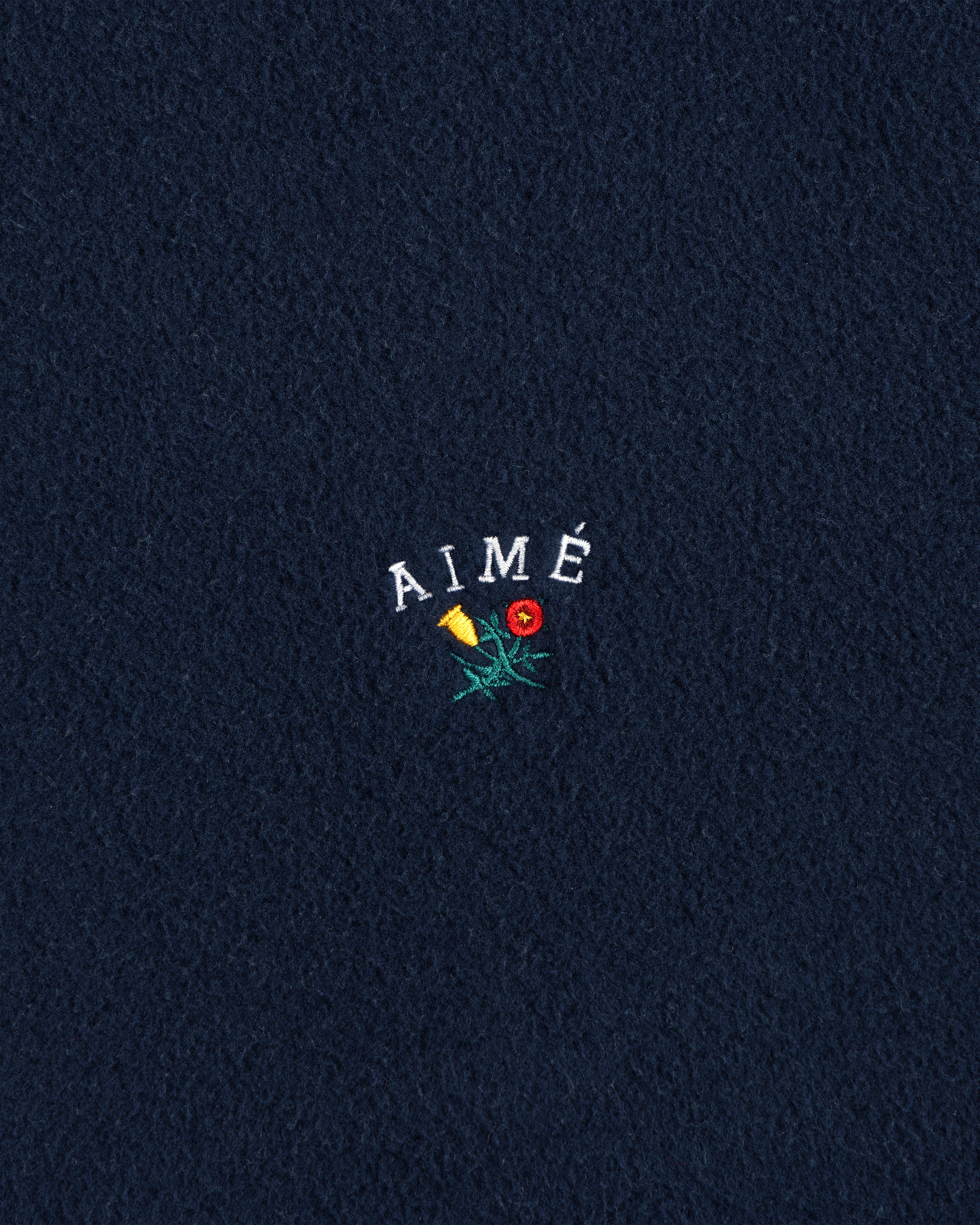 Navy Crest Fleece Casual Jacket with AIMÉ embroidered above a yellow-red flower with green stem and leaves.