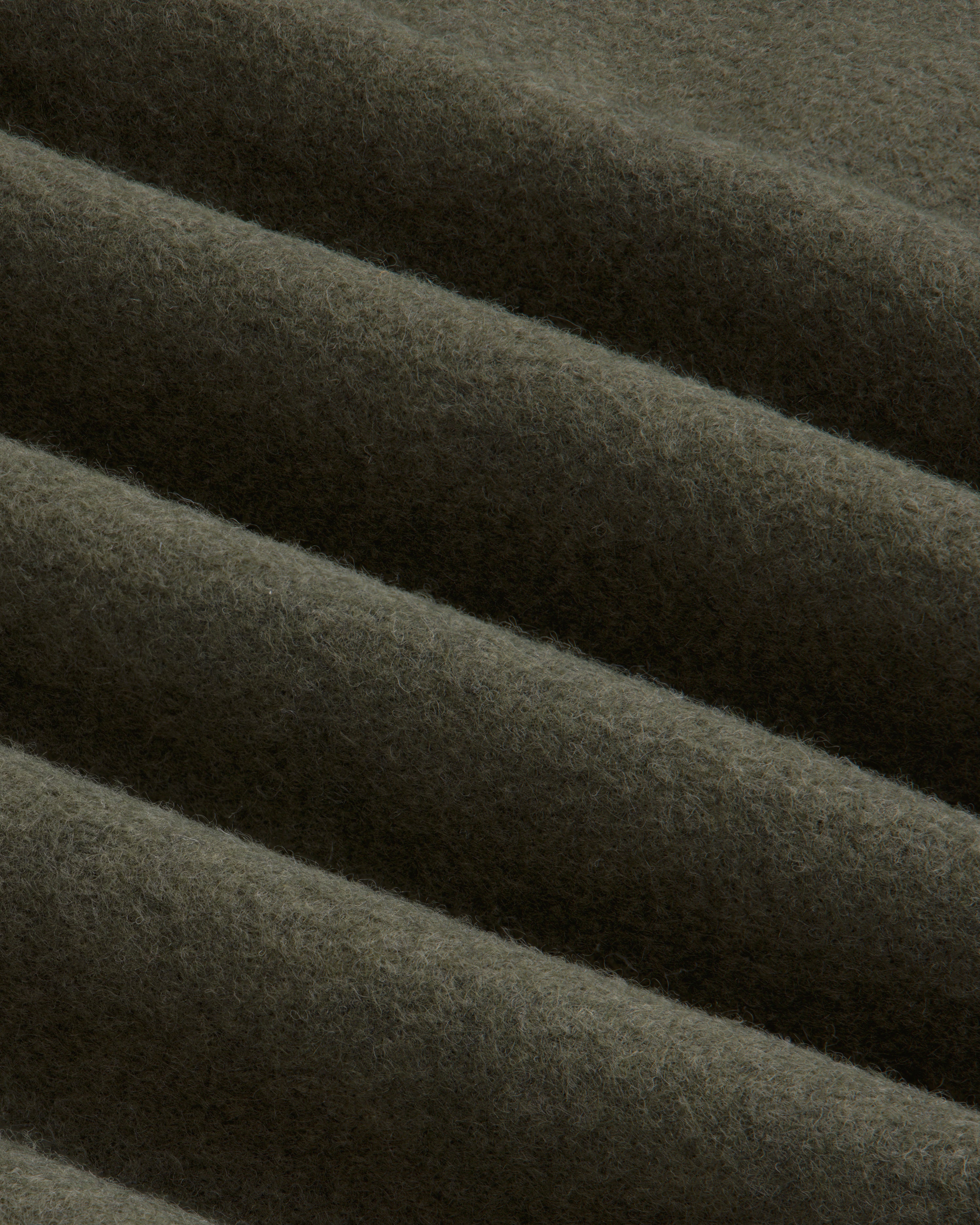Olive green Surplus Fleece Quarter Zip Pullover fabric with soft diagonal folds.