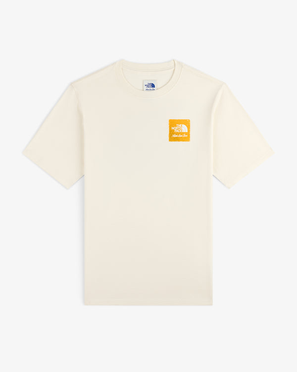 ALD / The North Face Logo Tee in cream with a small yellow logo on left chest, shown flat on a white background.