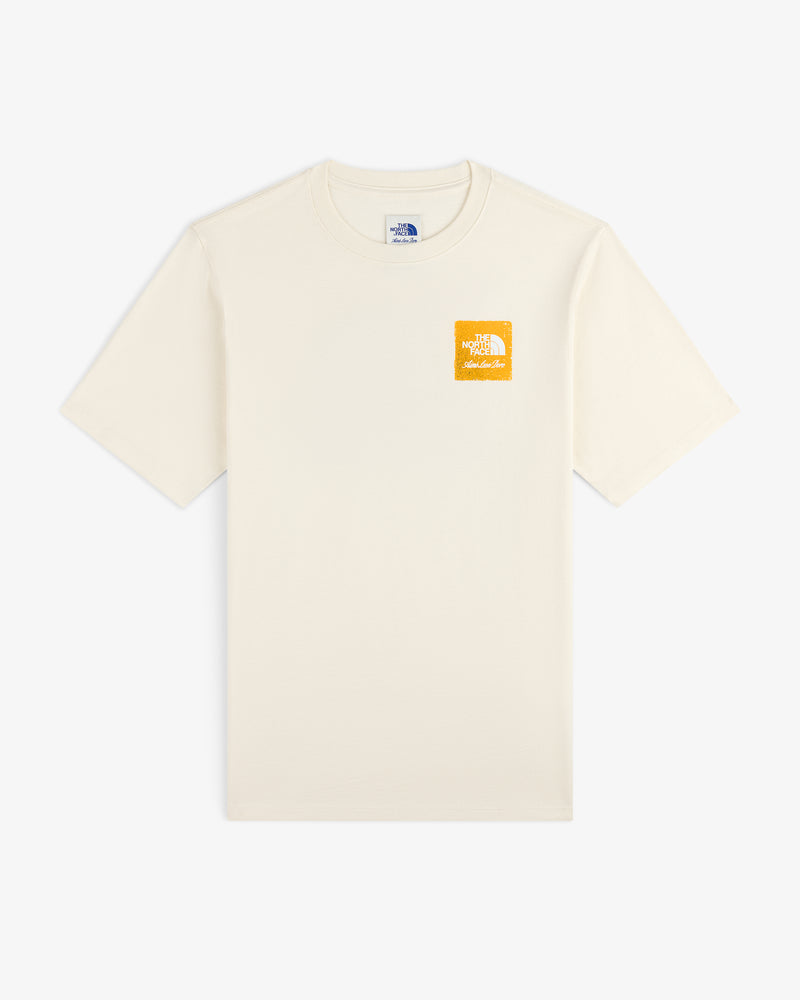 ALD / The North Face Logo Tee in cream with a small yellow logo on left chest, shown flat on a white background.