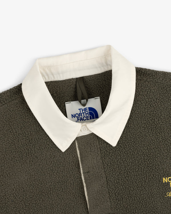 Close-up of ALD / The North Face Fleece Rugby in olive green with a white collar, showing the brand tag and collar.