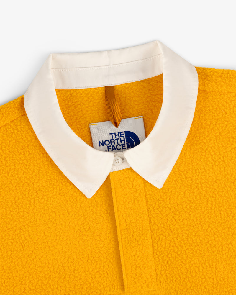 Close-up of yellow ALD / The North Face Fleece Rugby with white collar and visible brand tag.