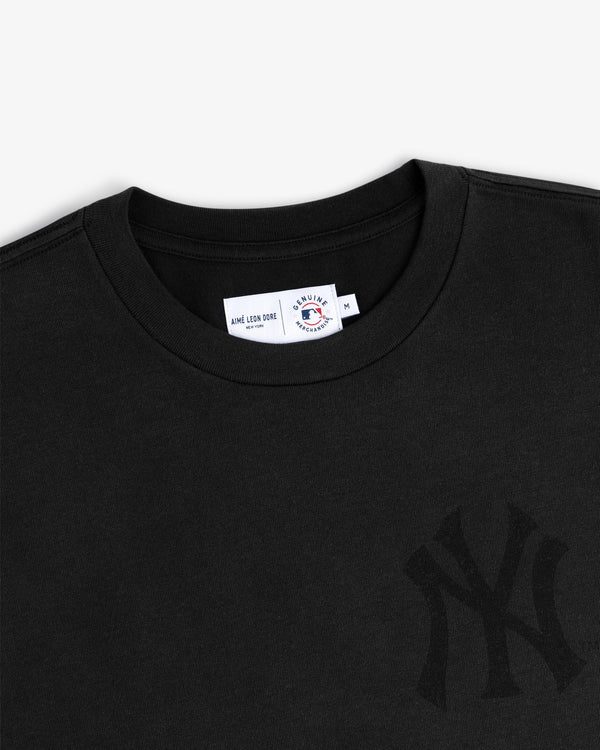 Yankees Washed Logo Tee: black T-shirt with New York Yankees logo and Aimé Leon Dore x MLB tag at collar.