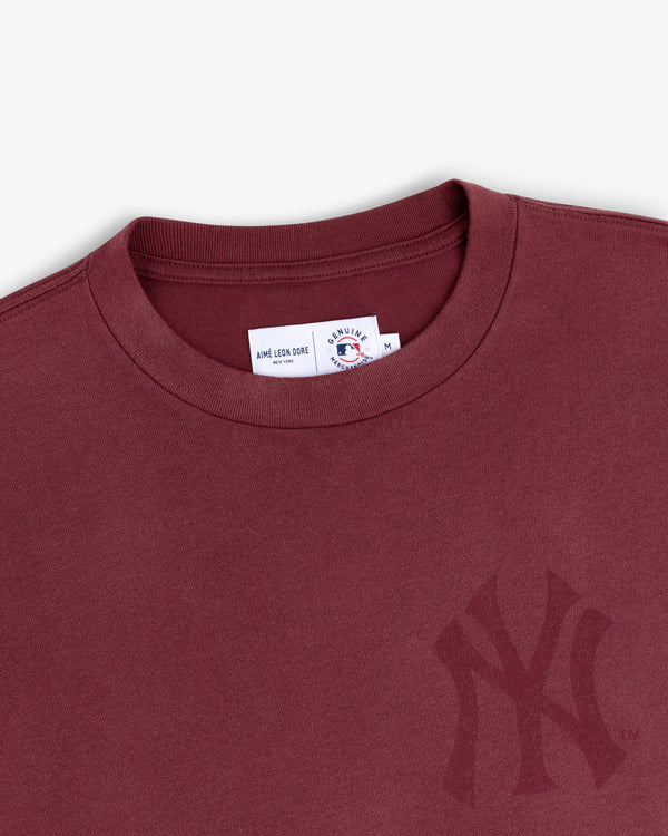 Yankees Washed Logo Tee: Burgundy crewneck with subtle Yankees logo and white collar tag.