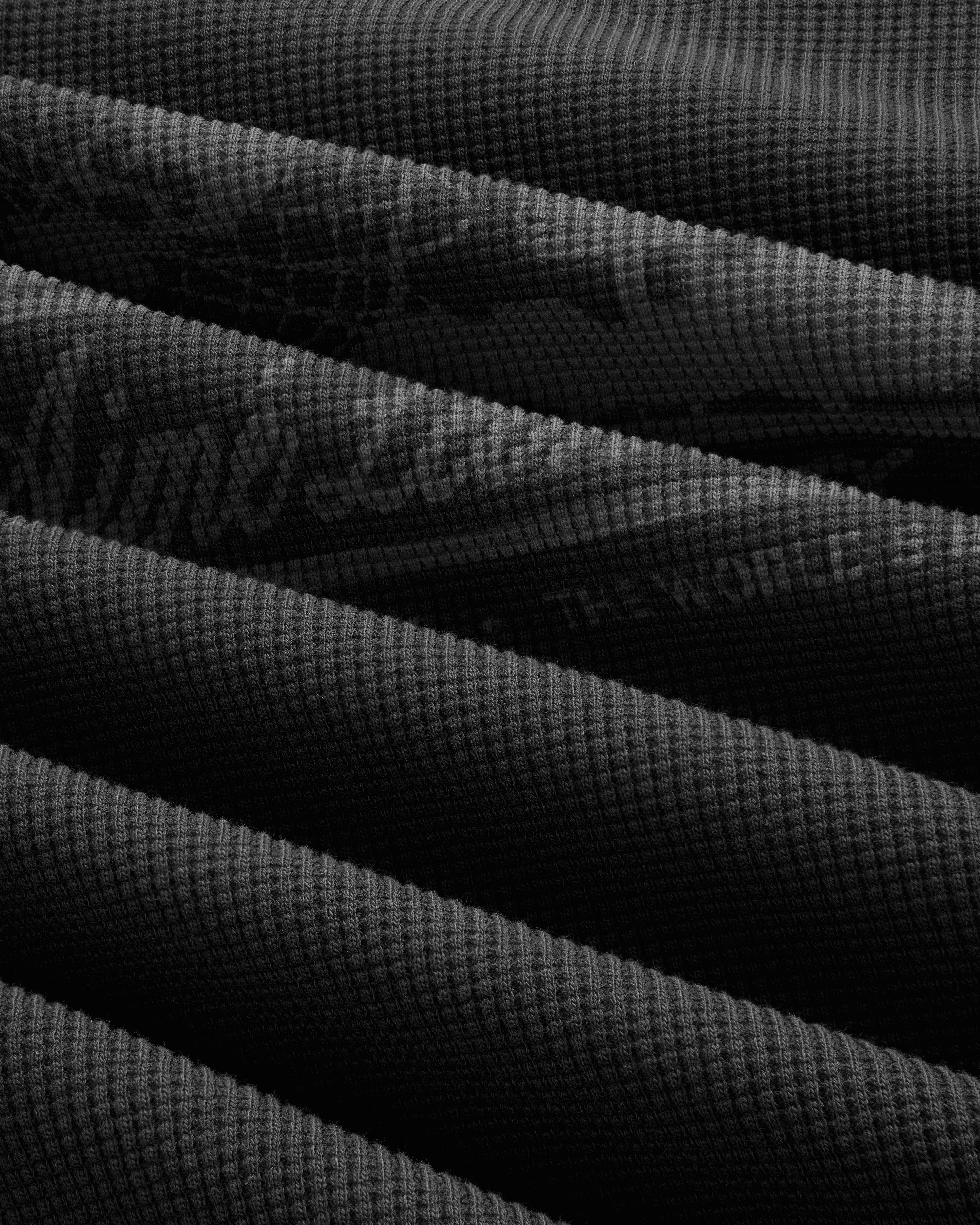 Dark, textured Long-Sleeve Unisphere Waffle Thermal with diagonal overlaps and a distinct waffle pattern.