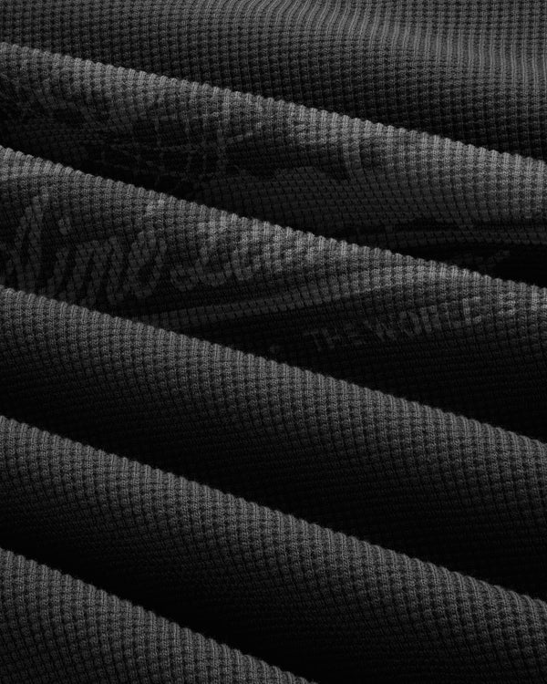 Dark, textured Long-Sleeve Unisphere Waffle Thermal with diagonal overlaps and a distinct waffle pattern.