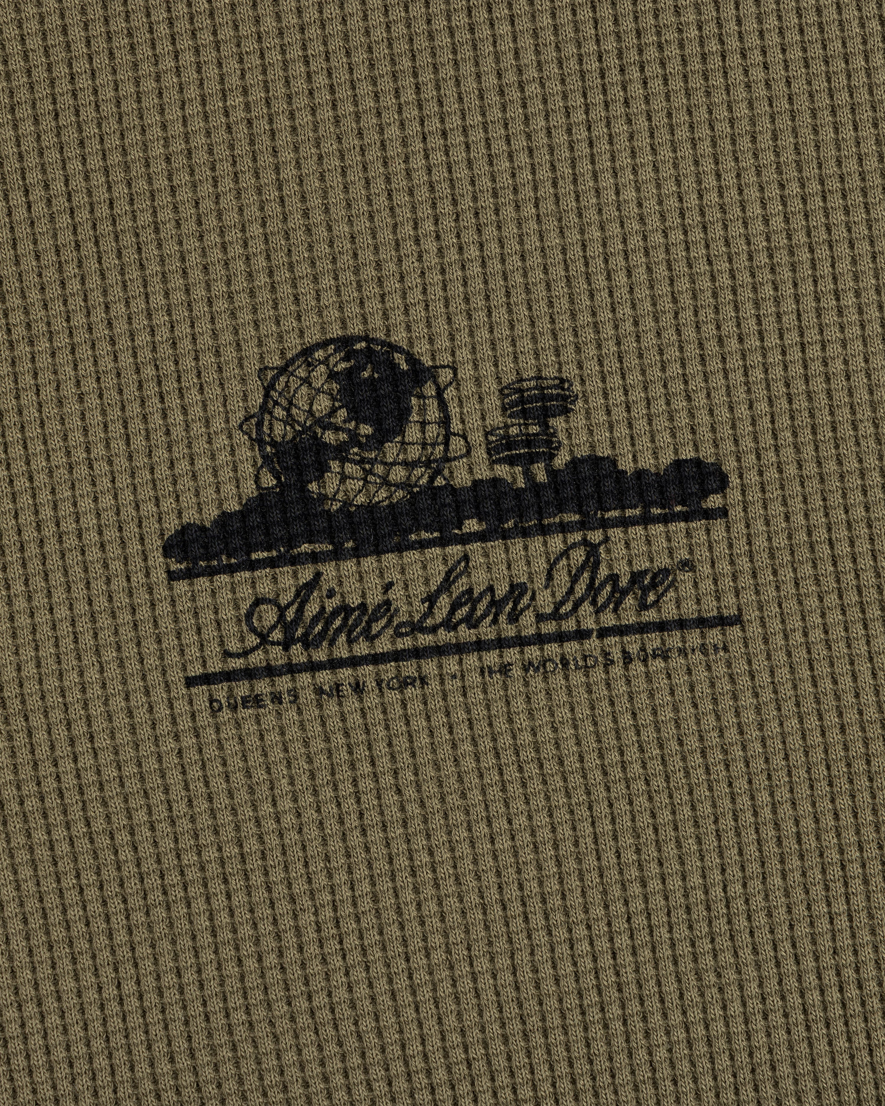 Olive-green waffle thermal with black Unisphere graphic and Ainé Bon Doné script on the front.