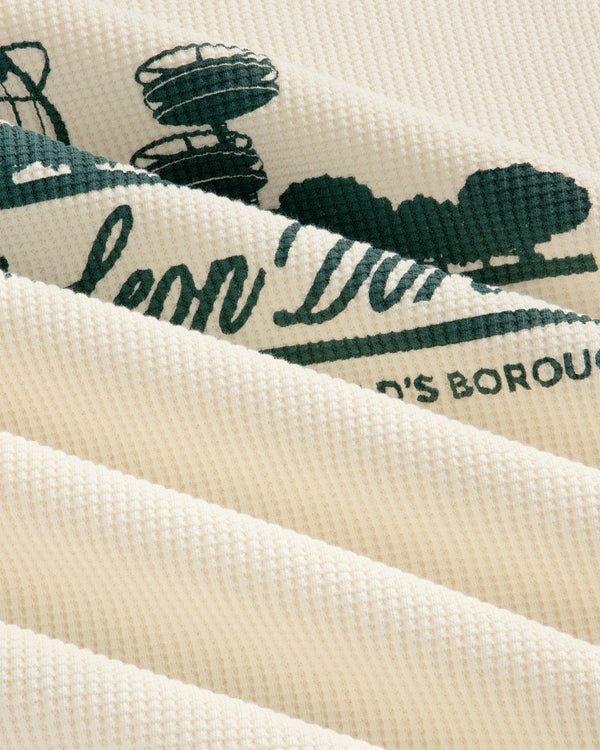 Cream waffle thermal with green Unisphere print, shown close-up with soft folds and ribbed texture.