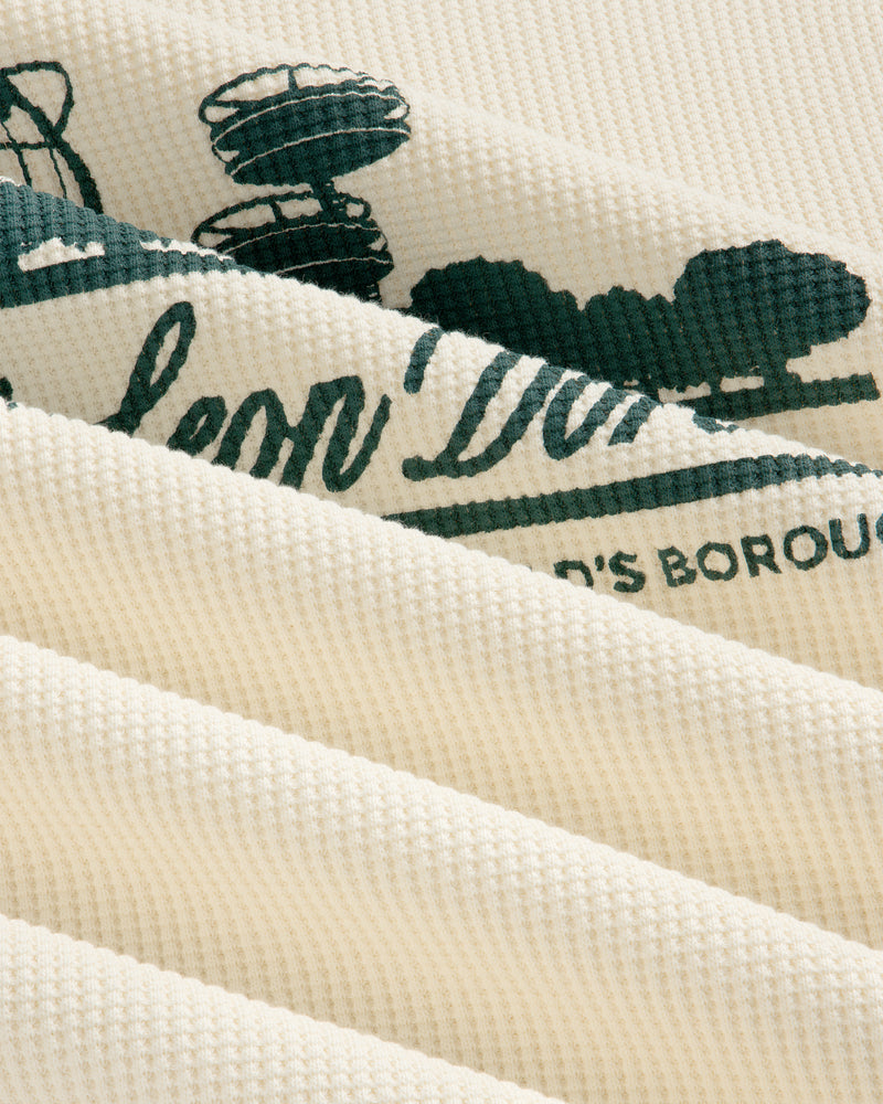 Cream waffle thermal with green Unisphere print, shown close-up with soft folds and ribbed texture.
