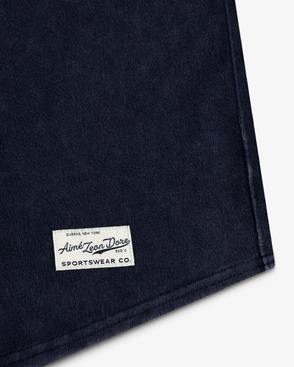 Close-up of a navy Mulberry Chainstitch Baseball Jersey with a white Aimé Leon Dore sportswear label in the corner.
