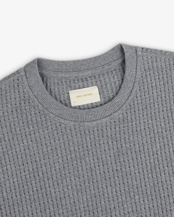 Grey Long-Sleeve Waffle Thermal shirt with a waffle-knit texture and a ribbed crew neckline.