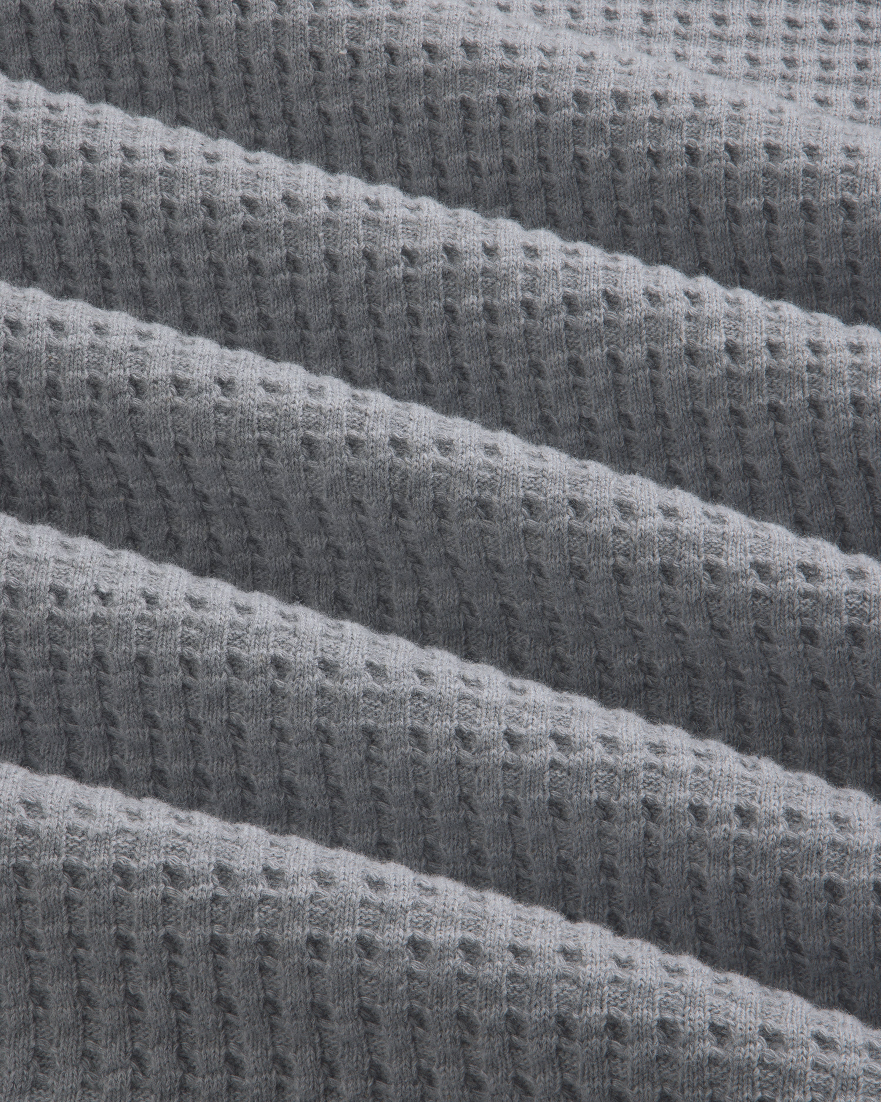 Grey Long-Sleeve Waffle Thermal fabric with diagonal folds.