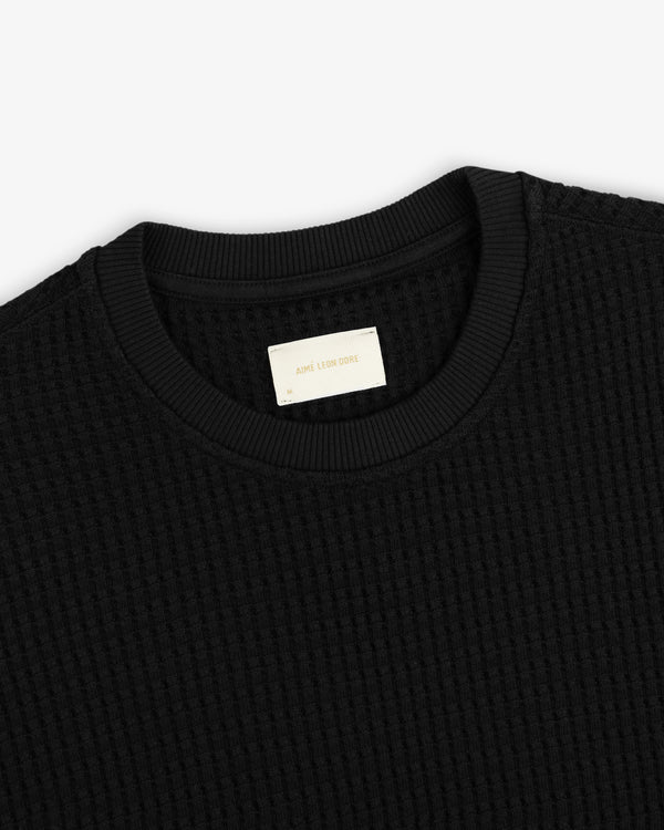Close-up of a black Long-Sleeve Waffle Thermal shirt with a ribbed crew neckline.