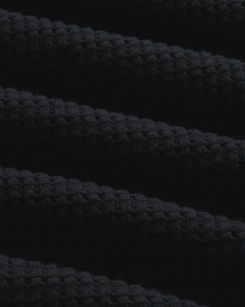 Close-up of black Long-Sleeve Waffle Thermal fabric with a textured waffle-knit pattern.