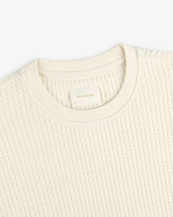 Cream-colored Long-Sleeve Waffle Thermal shirt with a waffle-knit texture and a clothing label inside the neckline.