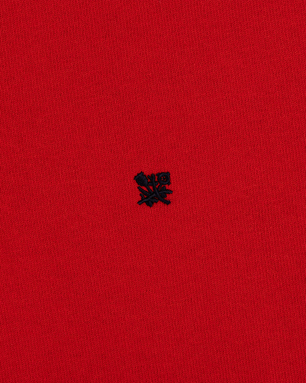 Red “Crest Rugby” fabric with a small, detailed black embroidered emblem at the center.