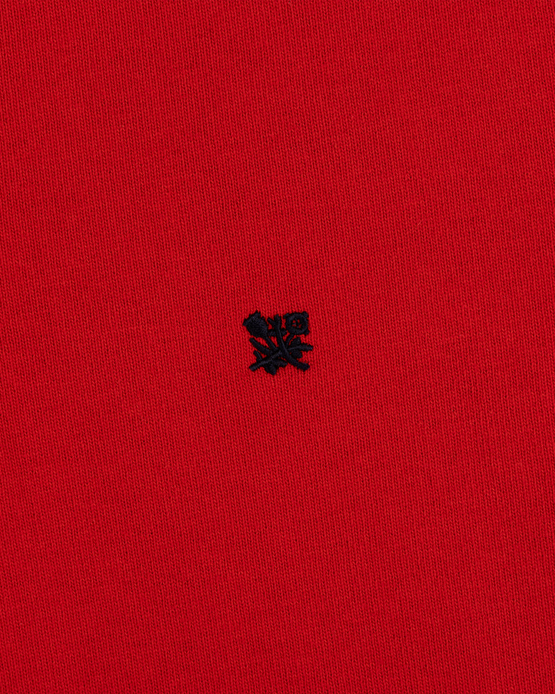 Red “Crest Rugby” fabric with a small, detailed black embroidered emblem at the center.