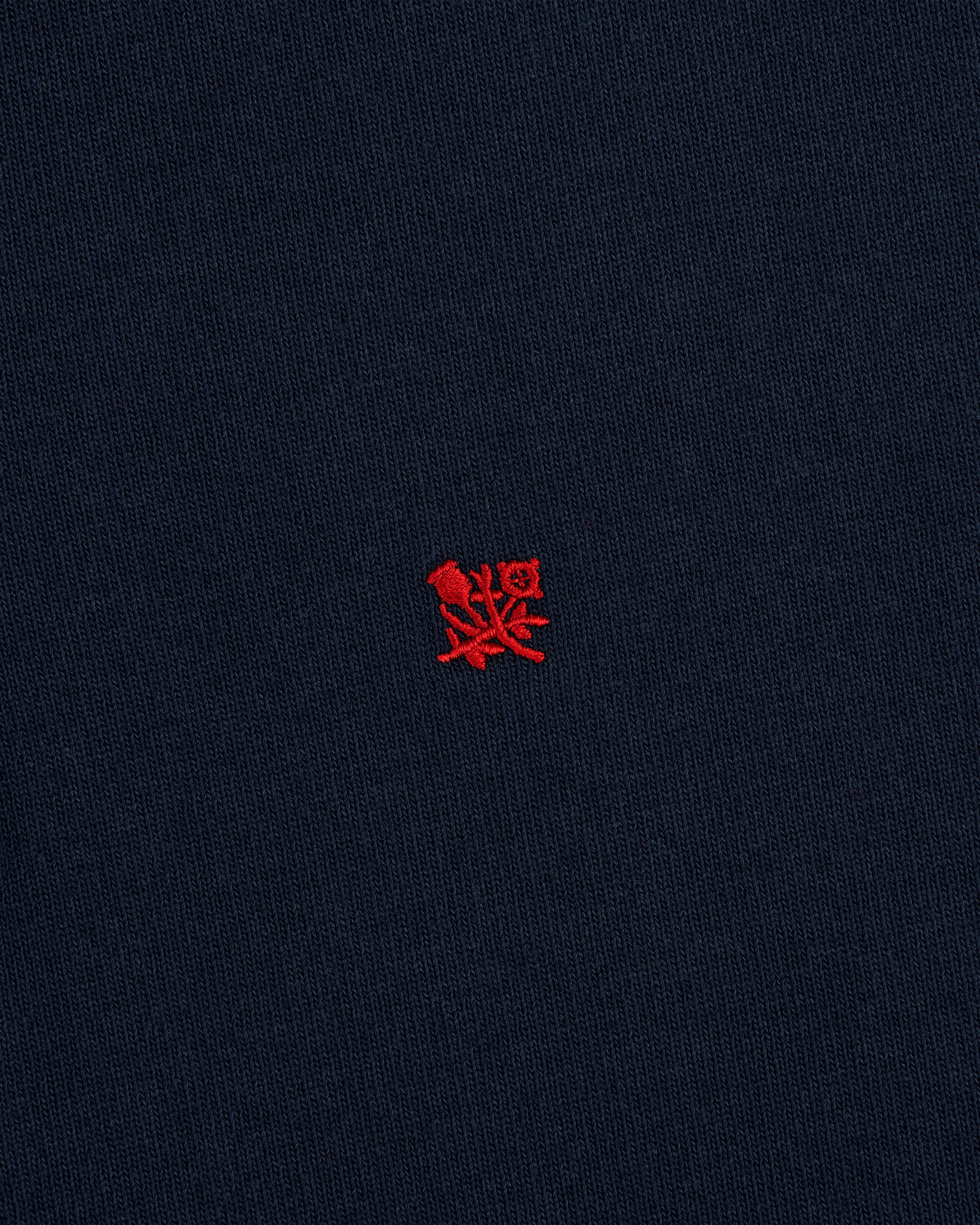 Crest Rugby: Navy blue fabric with a small red embroidered crest logo centered.