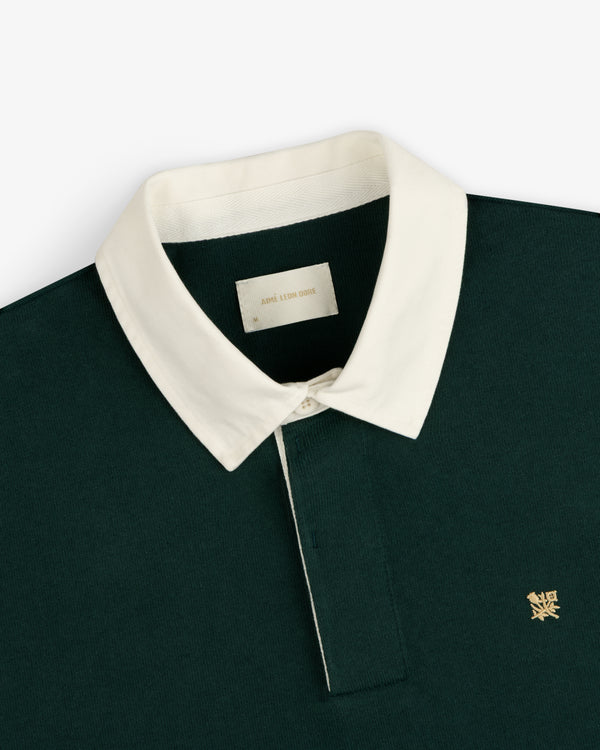 Crest Rugby: Dark green polo with white collar, yellow chest logo.