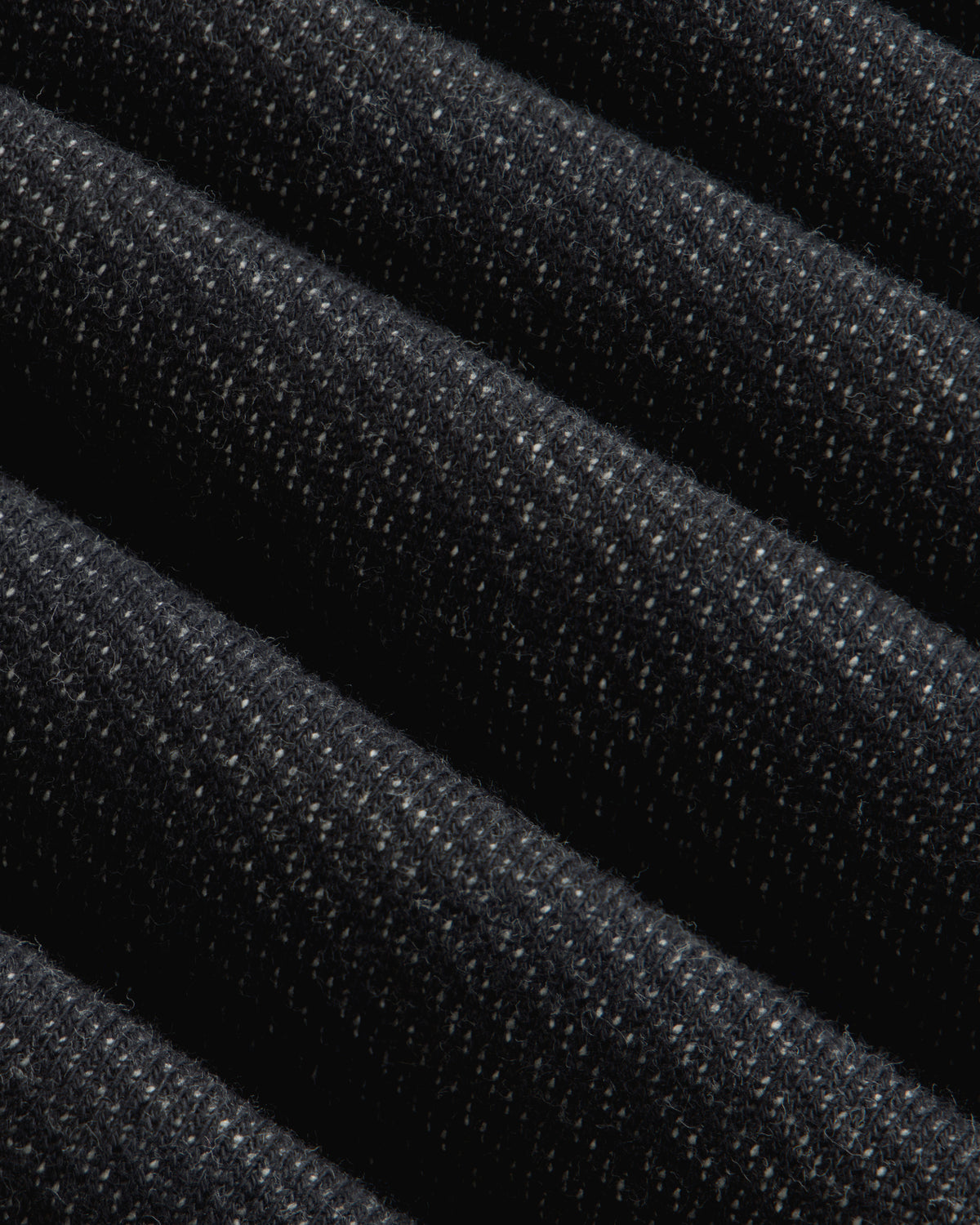 Close-up of the dark gray Terry Lounge Sweatpant featuring folded fabric with a textured, speckled weave.