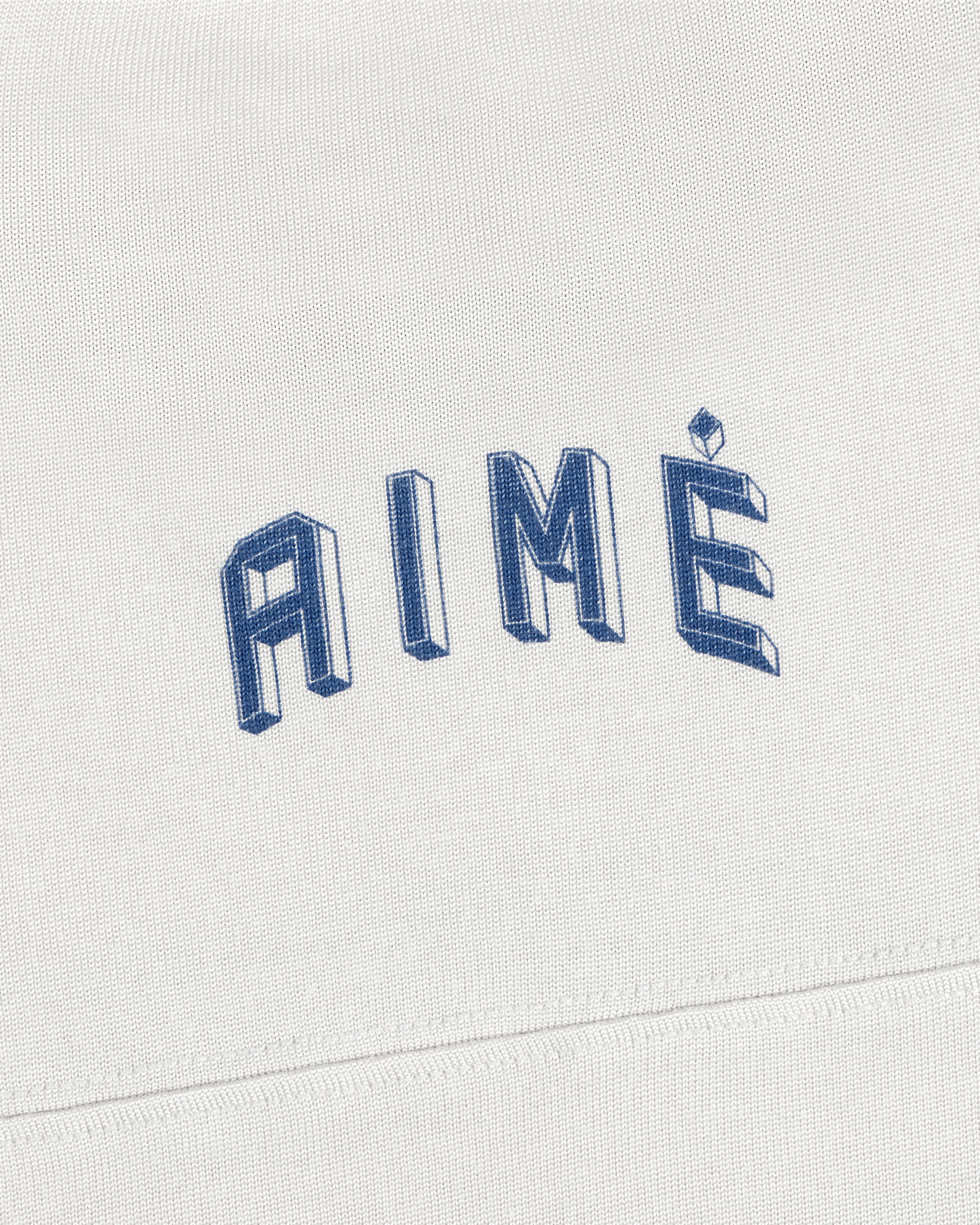 White Football Ringer Tee fabric with the word AIME embroidered in blue, three-dimensional lettering.