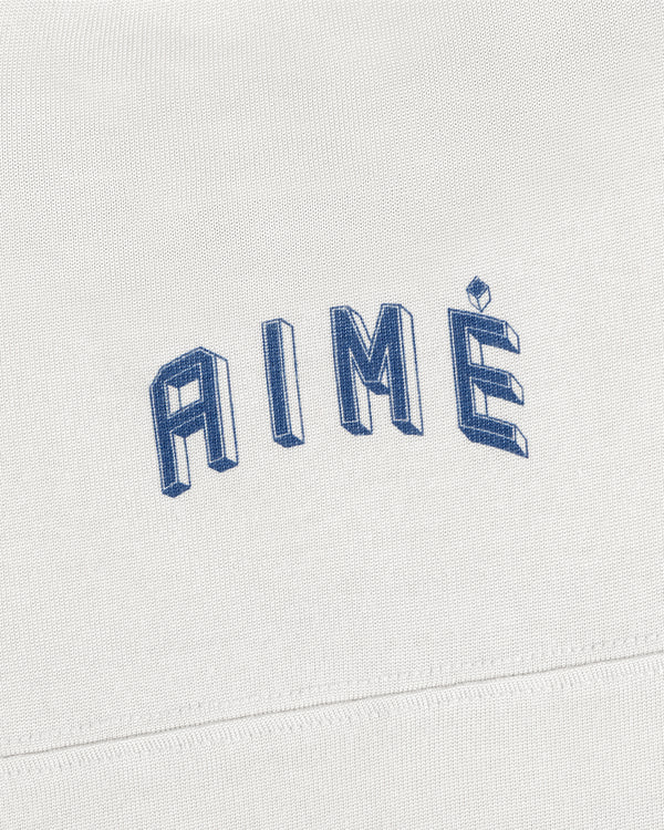 White Football Ringer Tee fabric with the word AIME embroidered in blue, three-dimensional lettering.