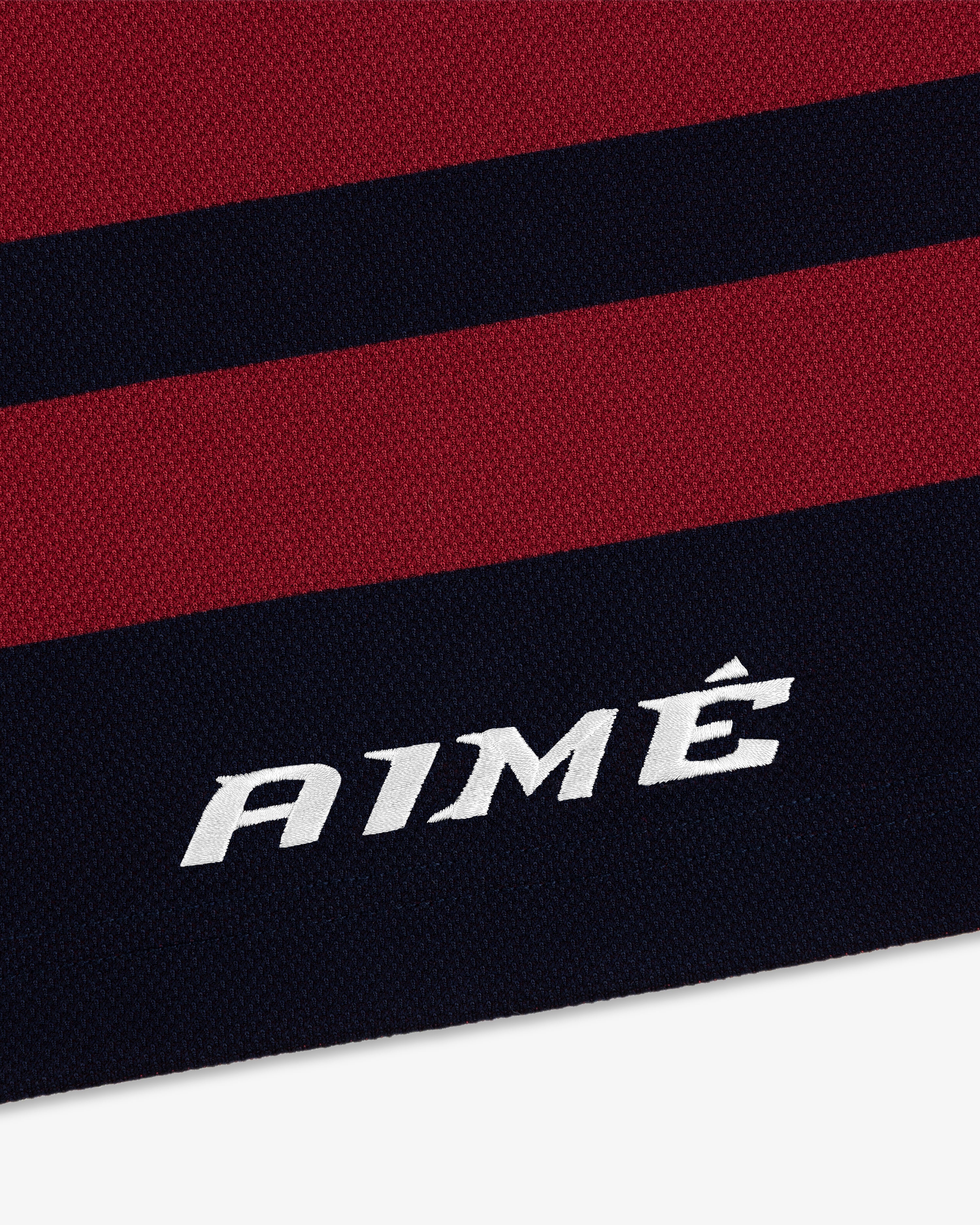 Close-up of a Team Aimé Hockey Jersey in dark red and navy stripes with AIMÉ embroidered in white.