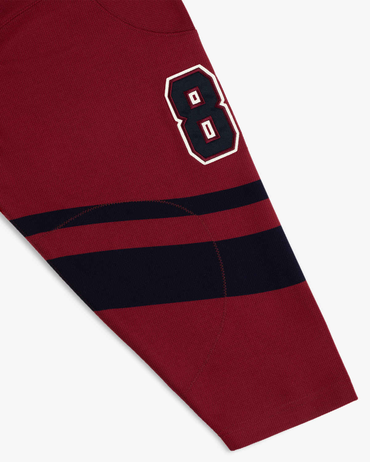 Team Aimé Hockey Jersey sleeve in maroon with a navy blue number 8 patch and two navy stripes on the forearm.
