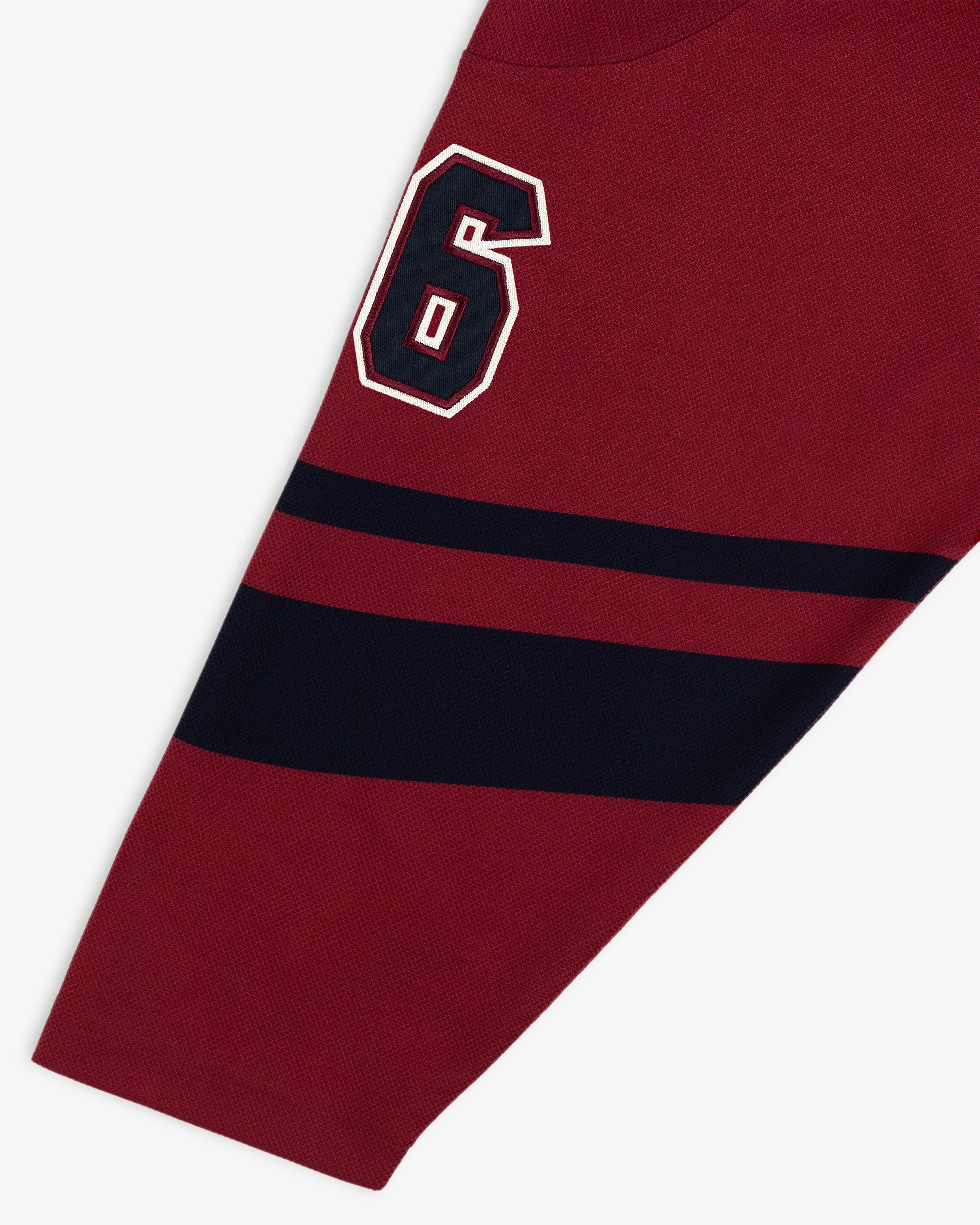 Team Aimé Hockey Jersey sleeve in maroon with a navy and white number 6 and two horizontal navy stripes.